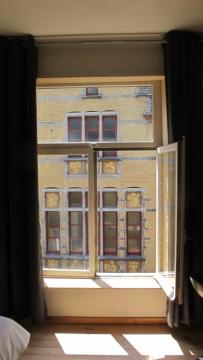 a window with a view of a building at Huize Maeterlinck in Ghent