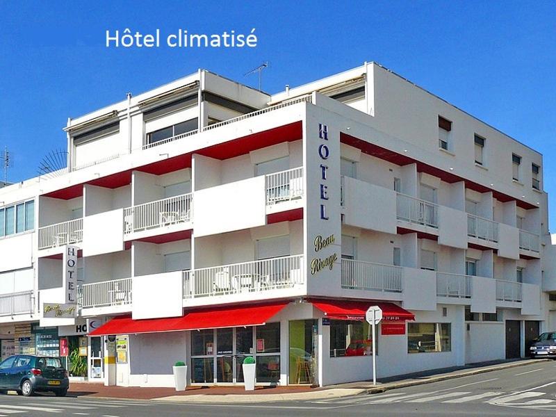ein großes weißes Gebäude mit roter Ausstattung in der Unterkunft Hôtel Beau Rivage in Royan