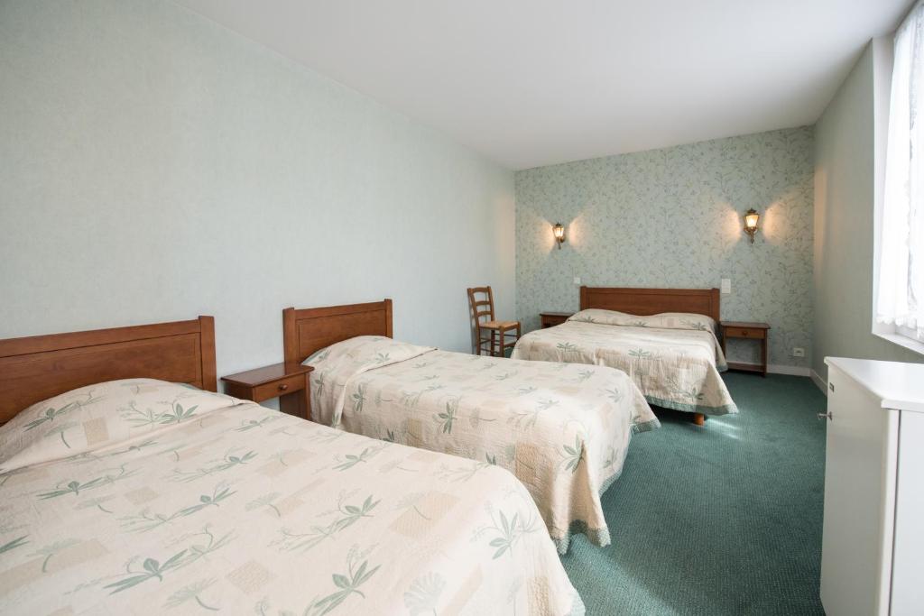 Postel nebo postele na pokoji v ubytování Les Ambassadeurs Logis Hotels et Restaurant