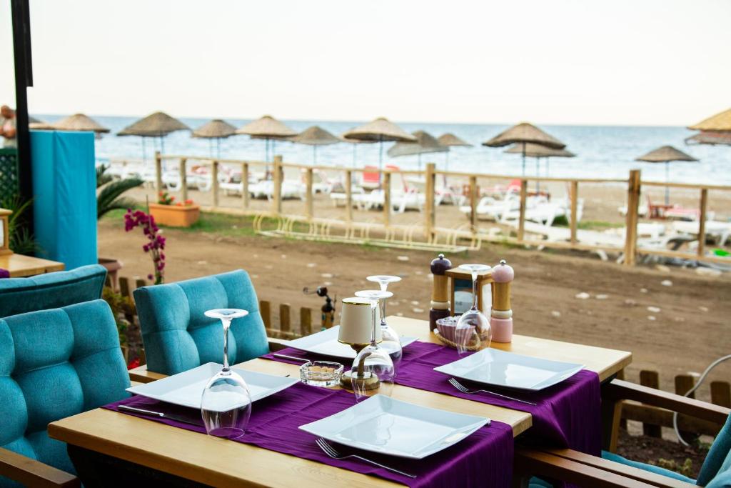 mesa con mantel púrpura y vistas a la playa en Kara Kedi Beach Bungalow, en Cıralı