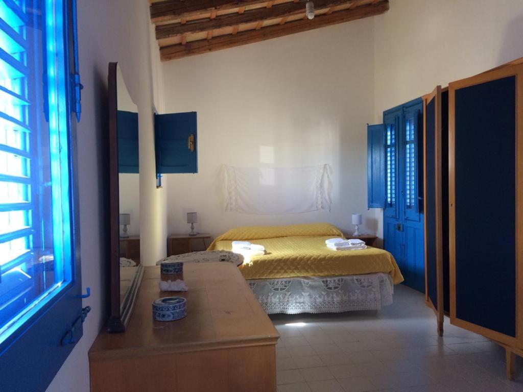 a bedroom with a bed with a yellow bedspread at BLU DIPINTO DI BLU in San Vito lo Capo