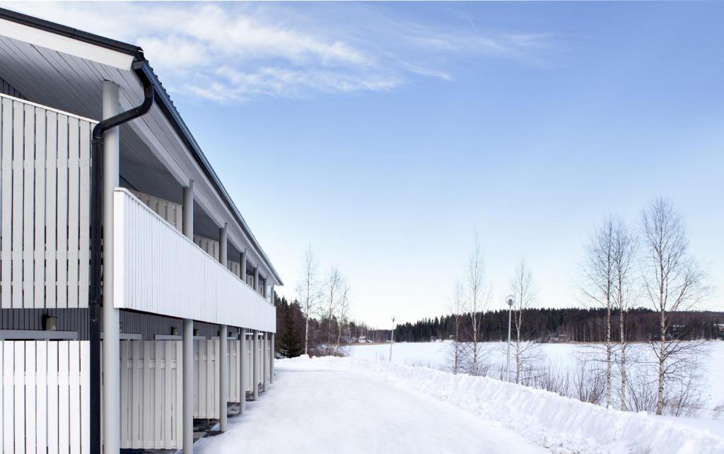 a snow covered road next to a building at Motel Patalahti in Jämsä