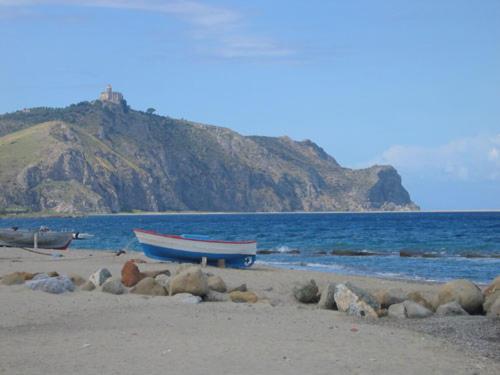two boats on a beach with a mountain in the background at Marinello in Oliveri