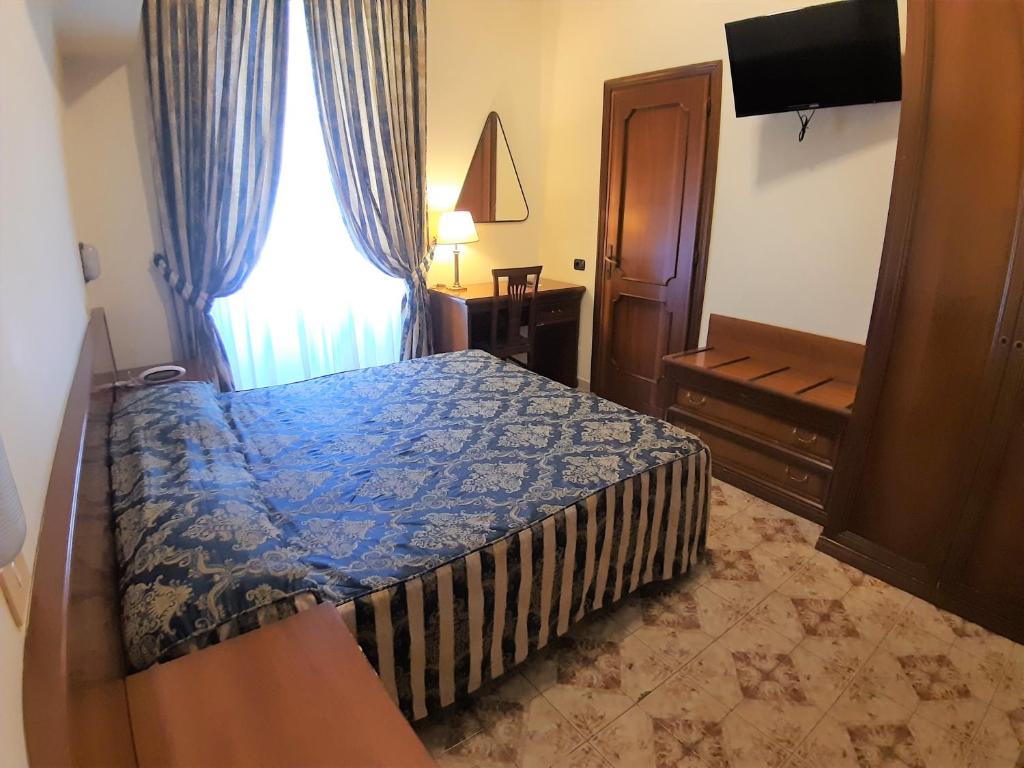 a bedroom with a bed and a dresser at Hotel Mariano in Rome