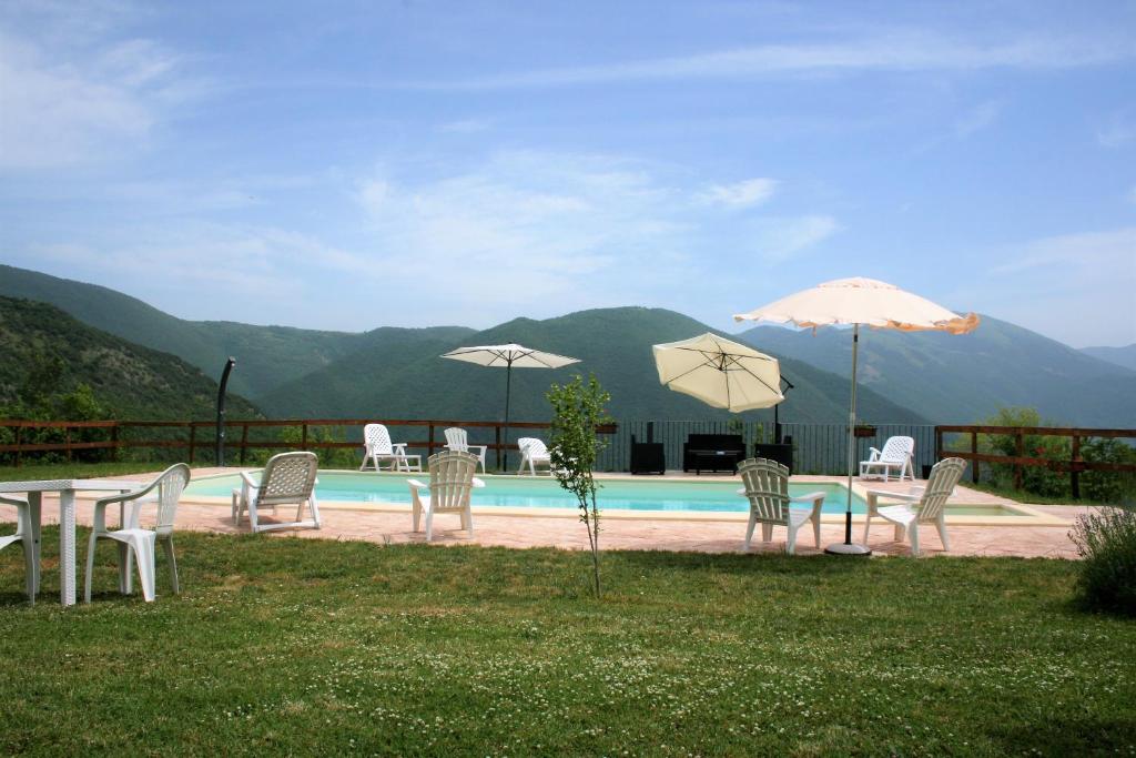 een groep stoelen en parasols naast een zwembad bij Agriturismo Tre Monti in Meggiano