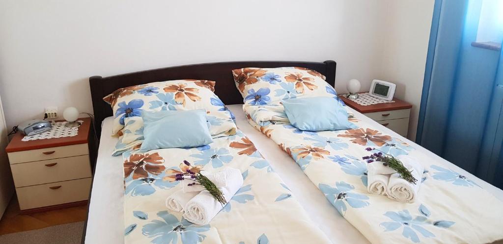 a bedroom with two beds with blue pillows at APARTMAN ANA in Mošćenička Draga