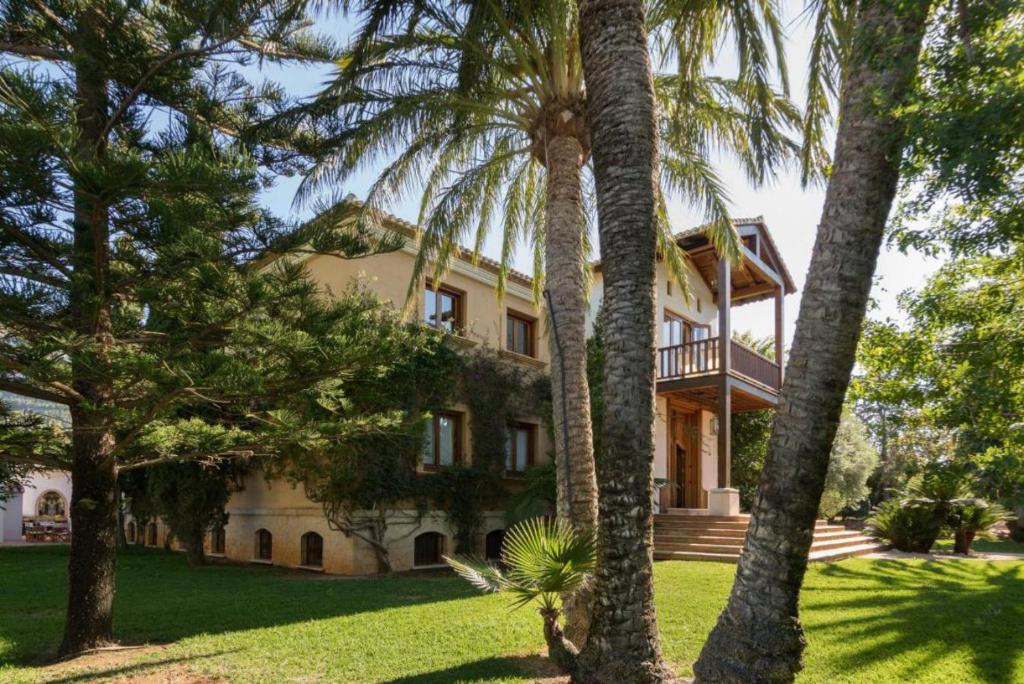 una casa con palmeras delante en Villa El Porto, en Denia