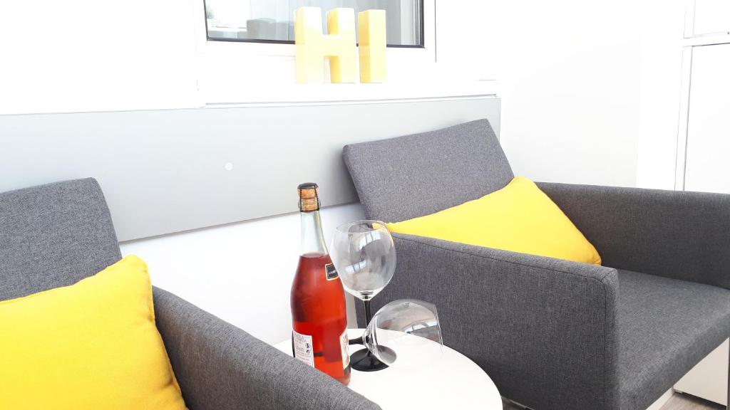 uma garrafa de vinho e um copo sobre uma mesa em Garsoniera Ultracentral em Constança