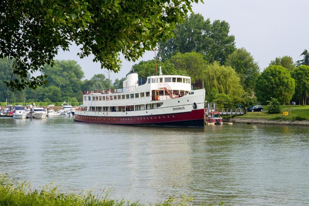 a large boat is docked on a river at De Logeerboot Dordrecht in Dordrecht