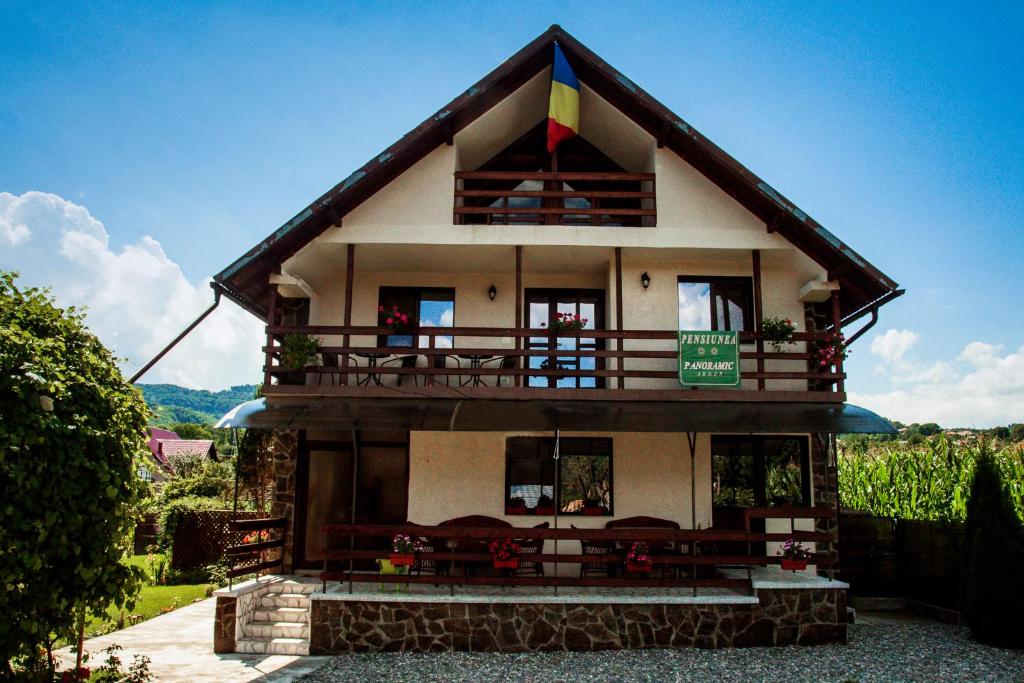 a house with a balcony on top of it at Pensiunea Panoramic in Corbeni