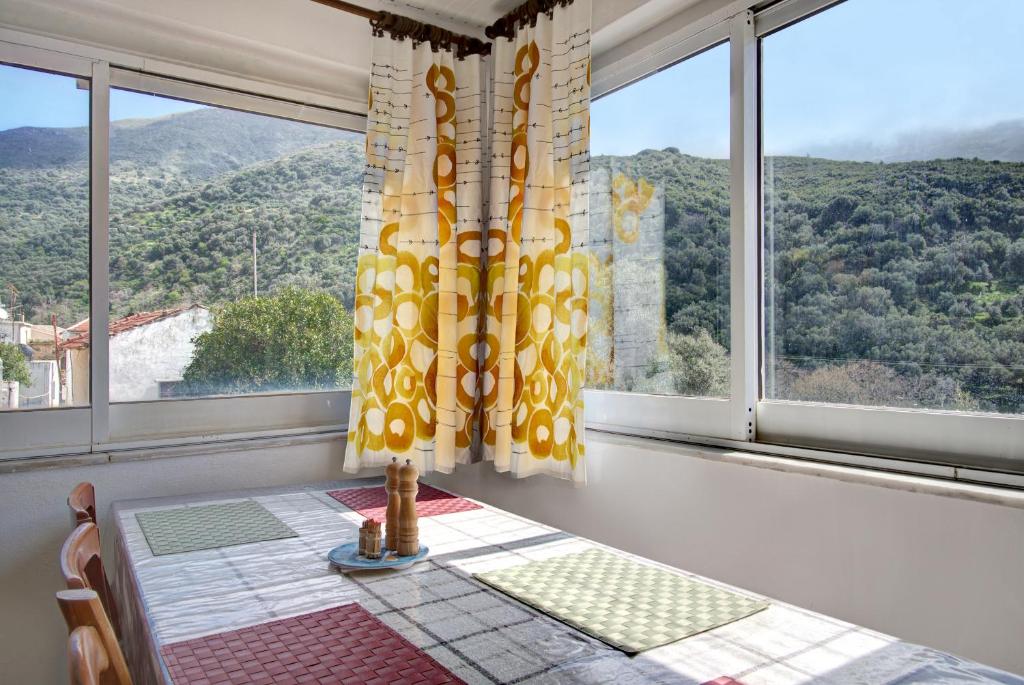 a dining room with a table and a large window at Traditional Cretan Country House (9klm from Elafonissi) in Plokamianá