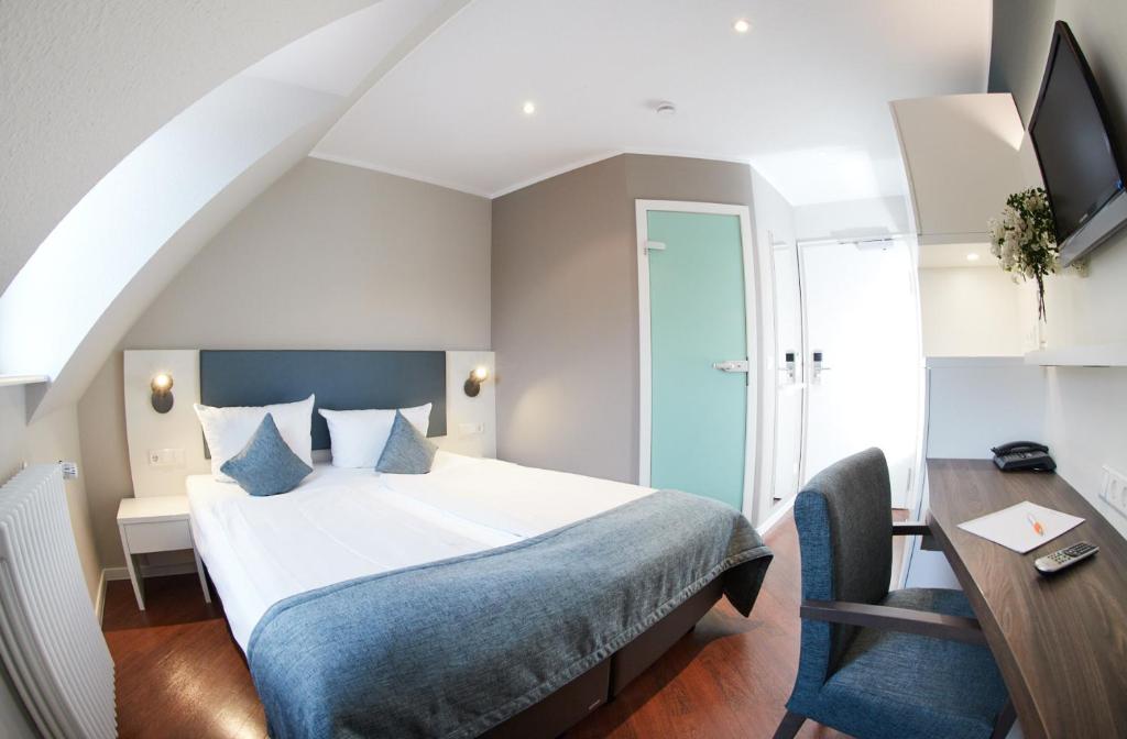Postel nebo postele na pokoji v ubytování Stadthotel Freiburg Kolping Hotels & Resorts