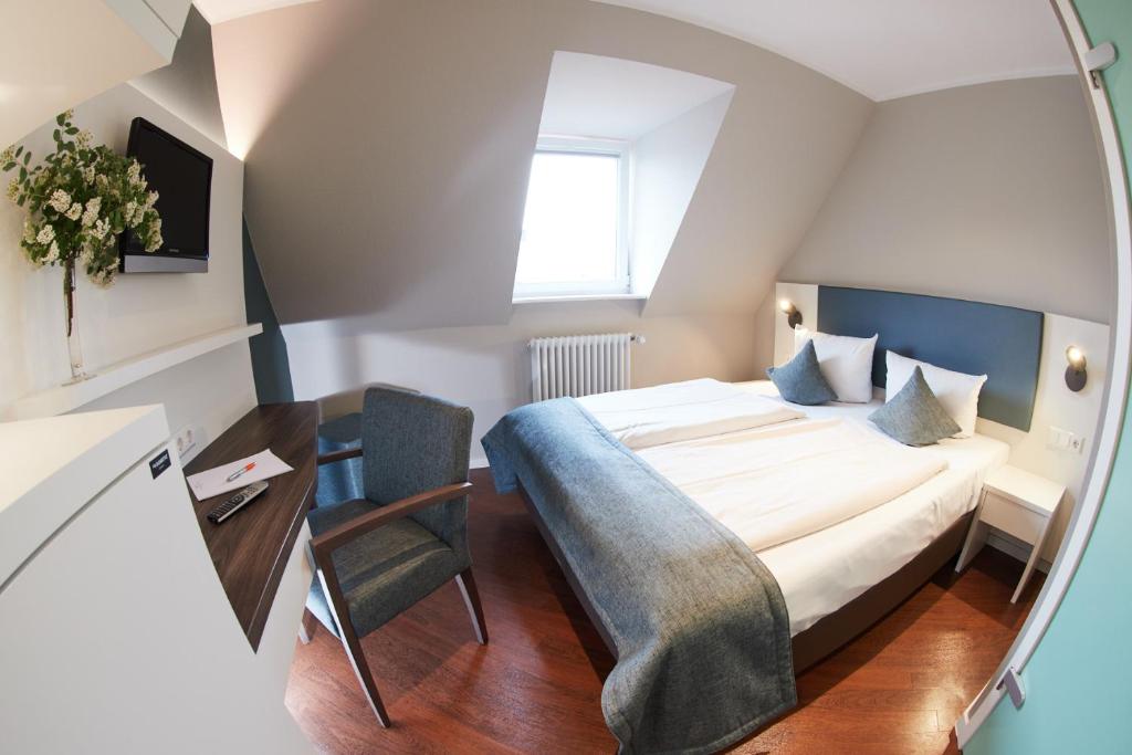 Postel nebo postele na pokoji v ubytování Stadthotel Freiburg Kolping Hotels & Resorts