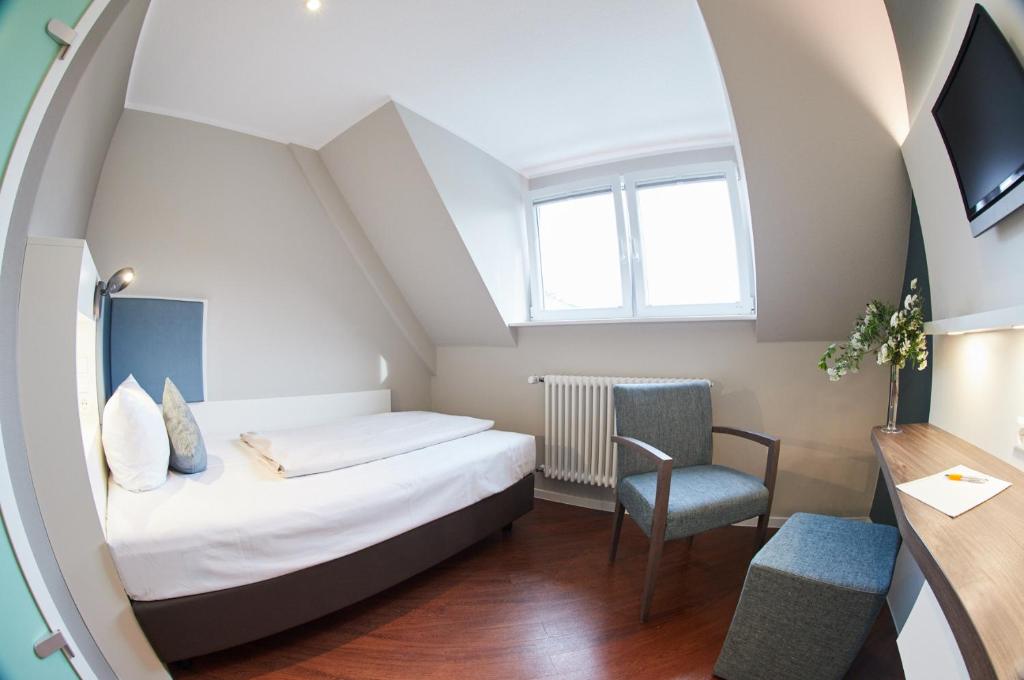 Postel nebo postele na pokoji v ubytování Stadthotel Freiburg Kolping Hotels & Resorts