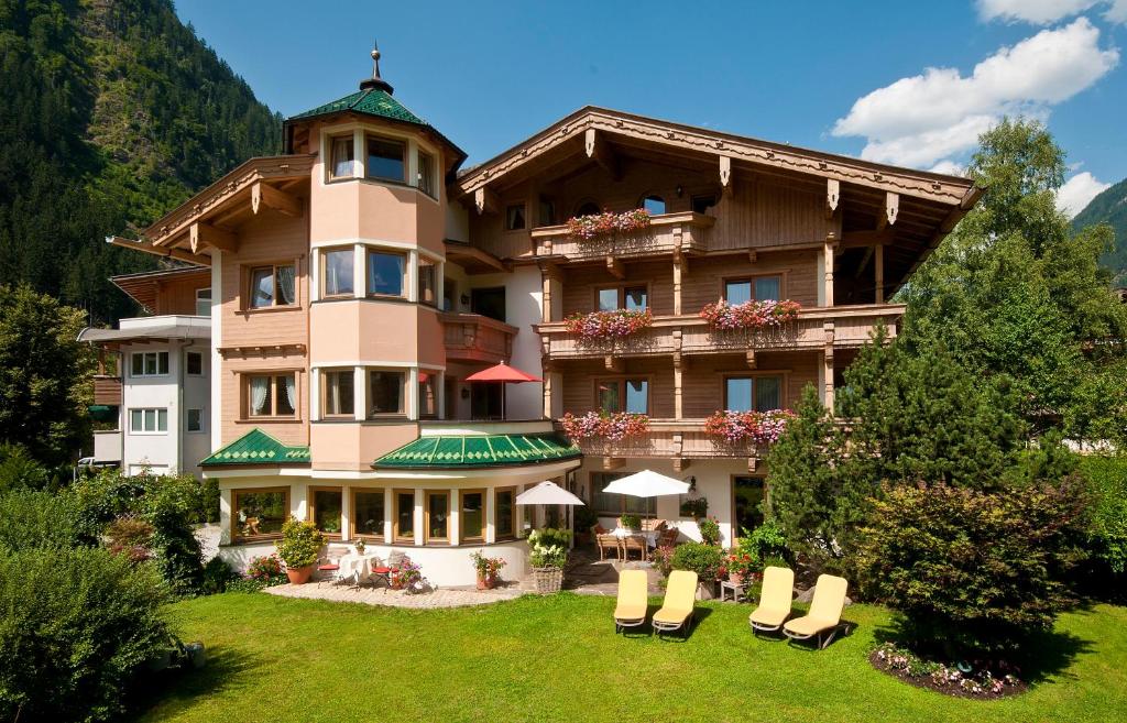 a large building with chairs in front of it at Hotel Garni Glockenstuhl in Mayrhofen
