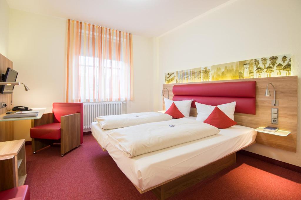 Postel nebo postele na pokoji v ubytování Stadthotel Freiburg Kolping Hotels & Resorts
