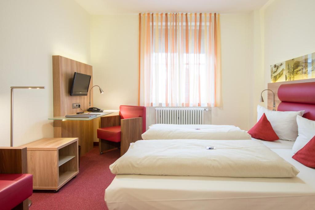 Postel nebo postele na pokoji v ubytování Stadthotel Freiburg Kolping Hotels & Resorts