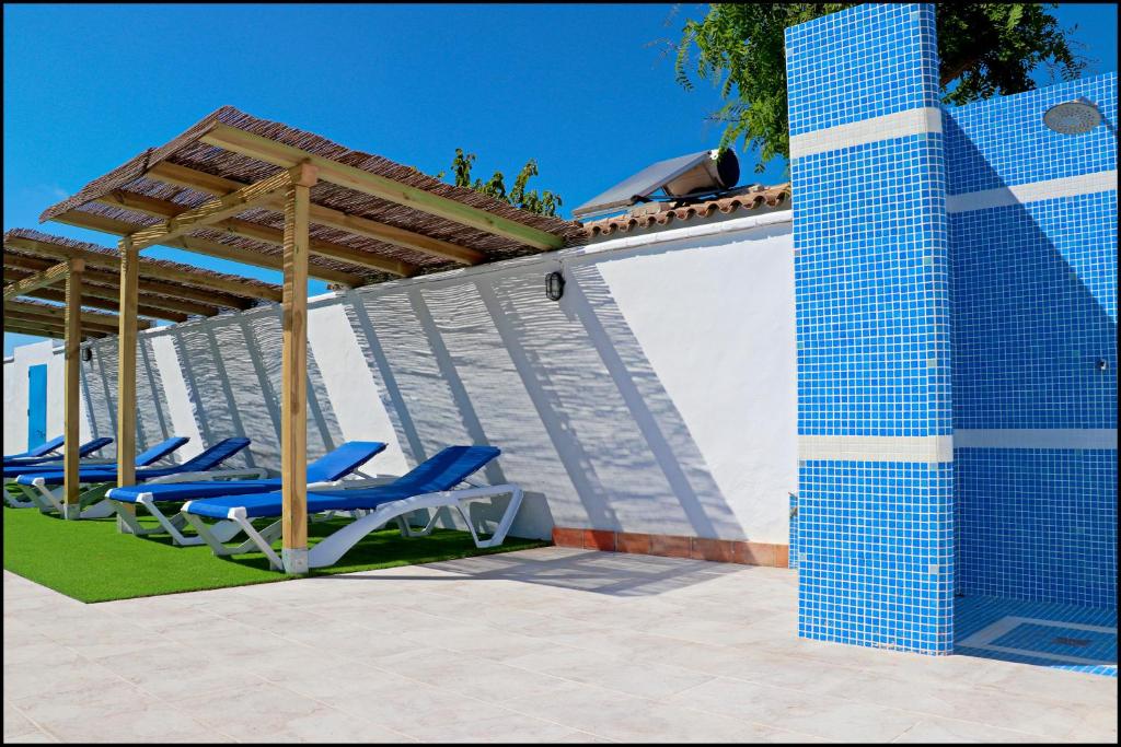 grupa leżaków pod pergolą na patio w obiekcie Bungalow La Roa V w mieście Conil de la Frontera