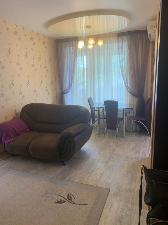 een woonkamer met een bank en een tafel bij Александра Поля проспект Апартаменты in Dnipro
