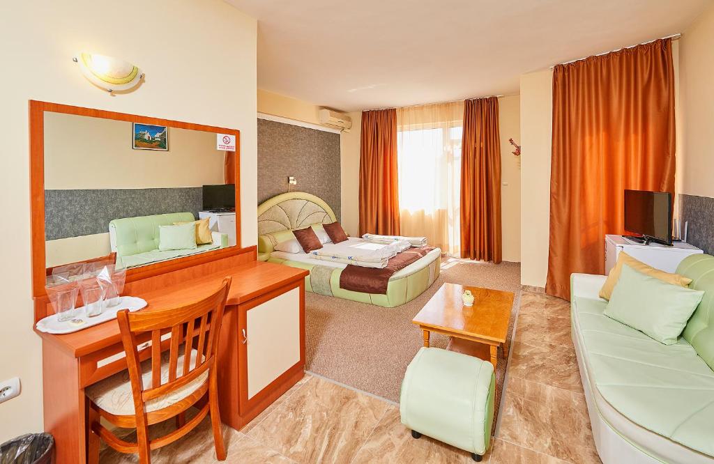 Habitación de hotel con sala de estar con sofá en Peneka Hotel en Pomorie