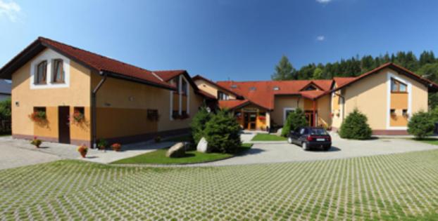 a house with a car parked in a driveway at Penzion Jantoľák in Zuberec