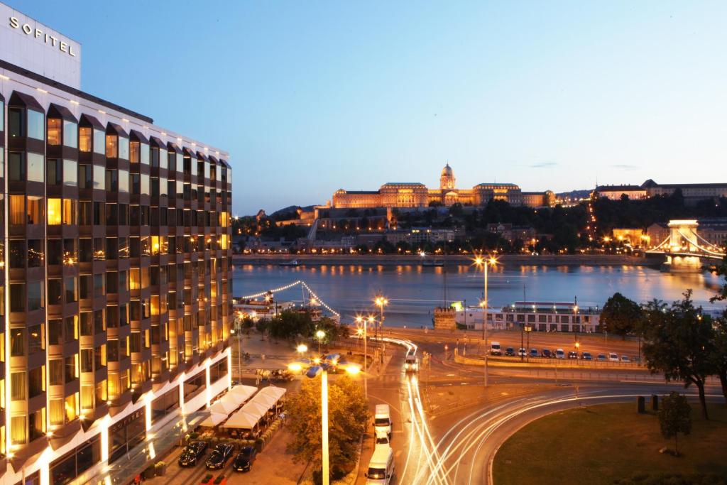 a view of a city at night with a building at Sofitel Budapest Chain Bridge in Budapest