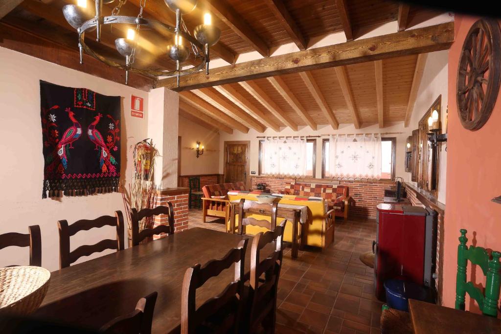 a dining room with tables and chairs in a restaurant at La Casa del Abuelo Simón in Fuente el Sauz
