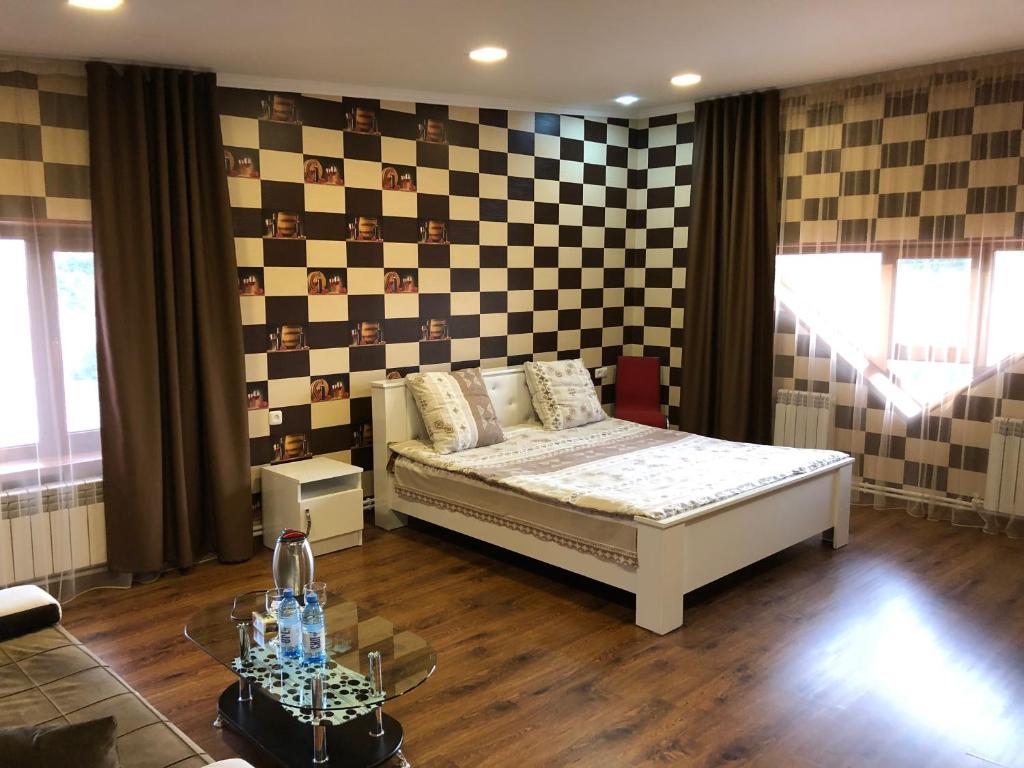 a bedroom with a bed and a checkerboard wall at Vale hotel&restaurant complex in Gyumri