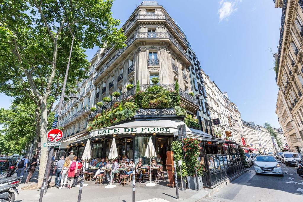 a building with people sitting outside of it on a street at TinyHouse Inn Saint-Germain-des-Près in Paris