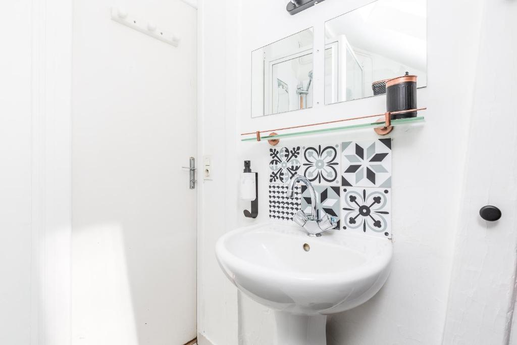a white bathroom with a sink and a mirror at TinyHouse Inn Saint-Germain-des-Près in Paris