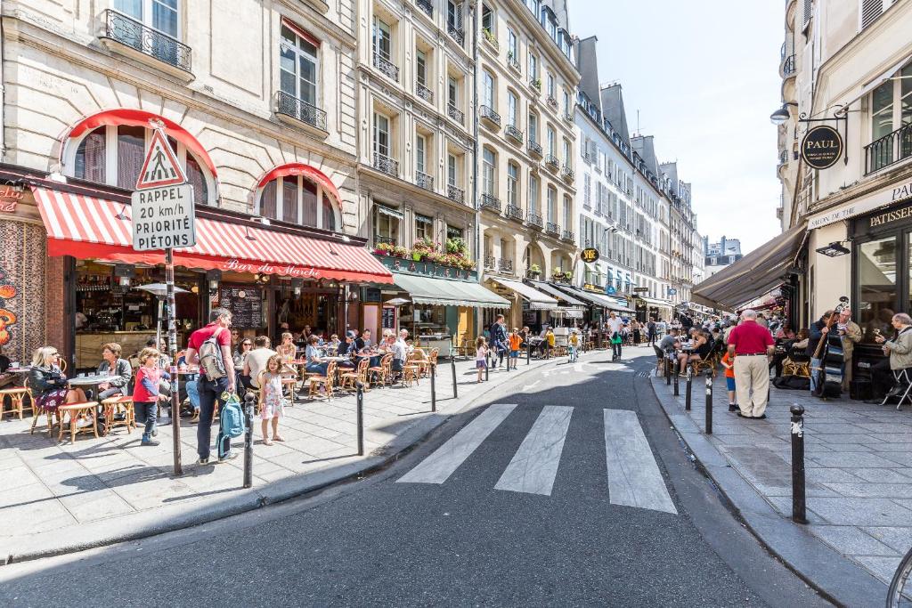 a busy city street with people and tables and buildings at TinyHouse Inn Saint-Germain-des-Près in Paris