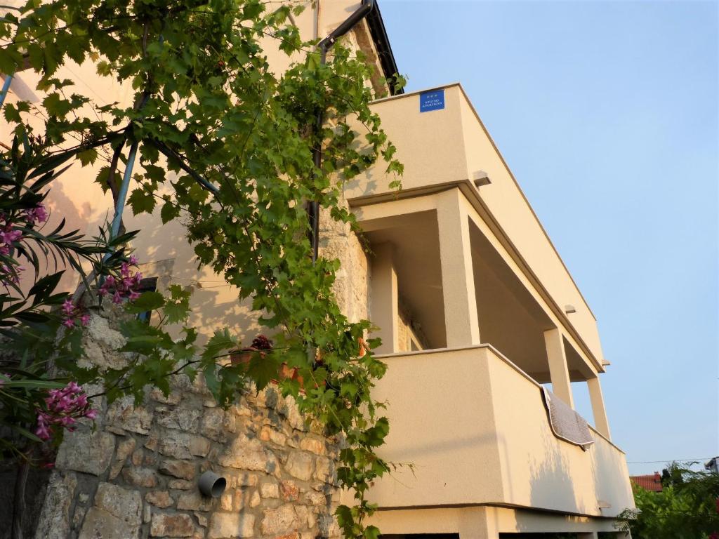 a house with flowers on the side of it at Studio apartmani Šverko in Punat