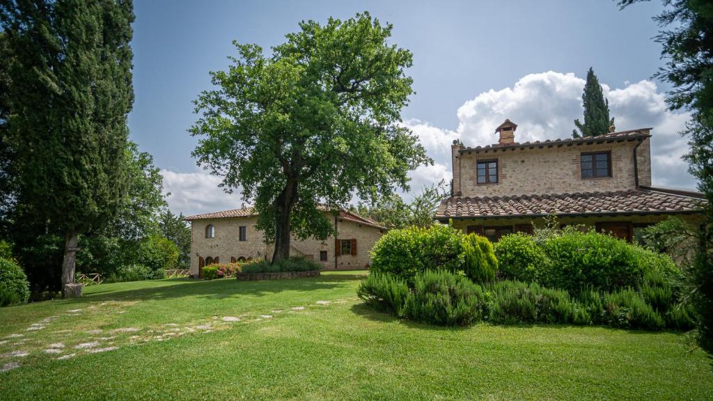 an exterior view of a house with a yard at Poggio Al Palio in San Lorenzo a Merse