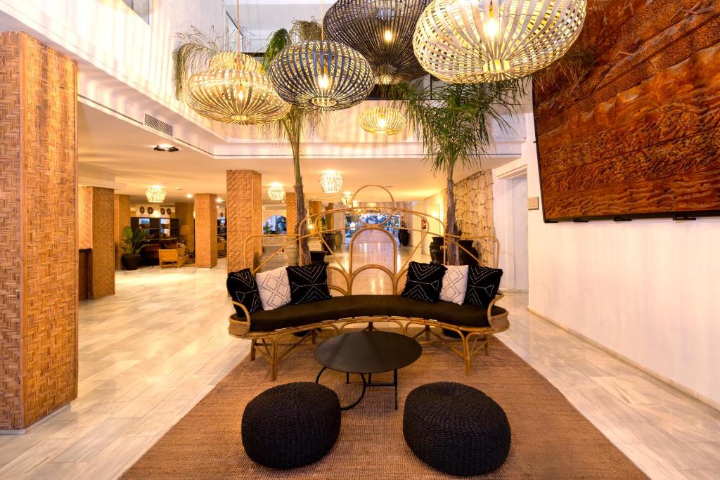 a lobby with a couch and a table and chandeliers at FERGUS Style Bahamas in Playa d'en Bossa