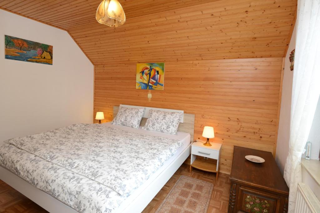 een slaapkamer met een bed en een houten muur bij Brane Apartment in Bohinj