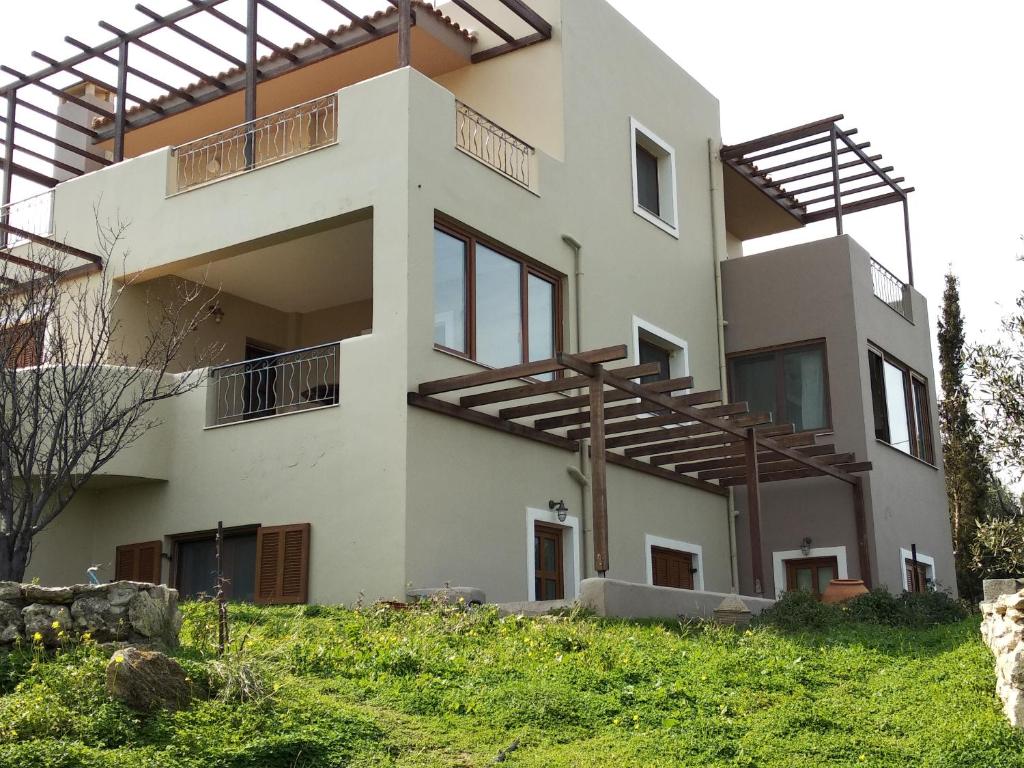 a house with wooden balconies on the side of it at Serapis Country House on the hill above Heraklion Off grid in Archanes