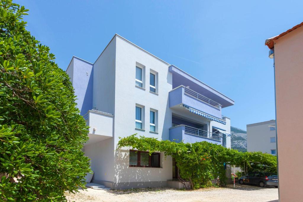 a white house with trees in front of it at Blue House in Makarska