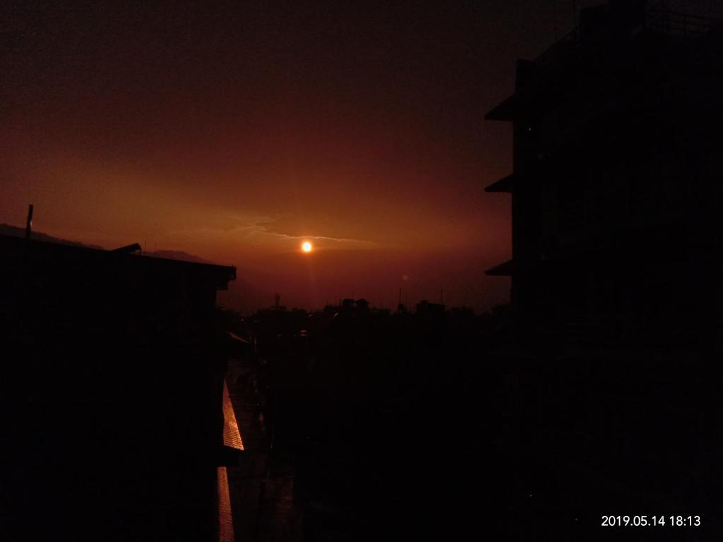una puesta de sol con la puesta de sol en la distancia en Hotel Aarjan And Restaurant, en Pokhara