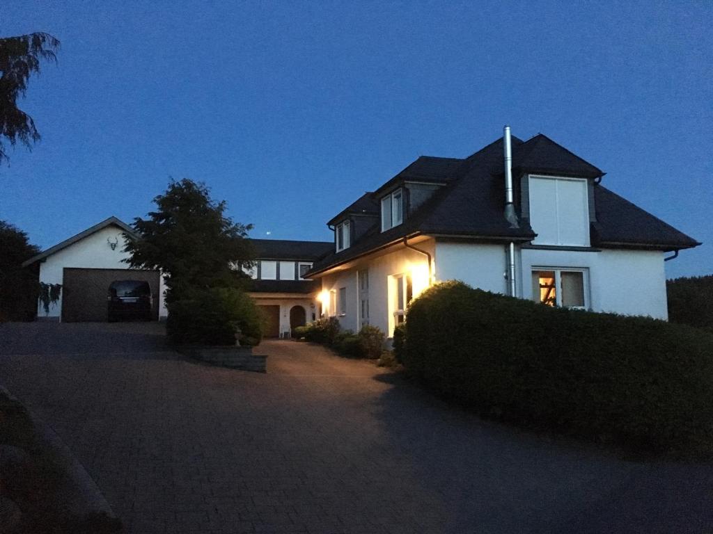 ein großes weißes Haus mit eingeschaltetem Licht in der Unterkunft Willstein in Bad Berleburg