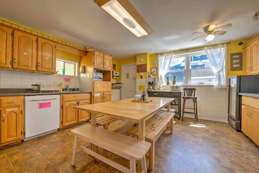 a kitchen with a wooden table and a dining room at HI Charlottetown Backpacker's Inn in Charlottetown