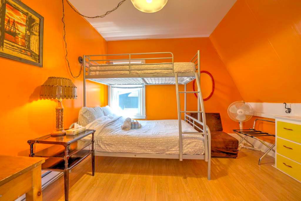 a bedroom with a bunk bed in an orange wall at HI Charlottetown Backpacker's Inn in Charlottetown