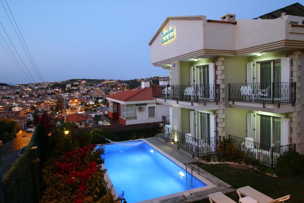 um hotel com piscina em frente a um edifício em Kandıra Butik Hotel em Cesme