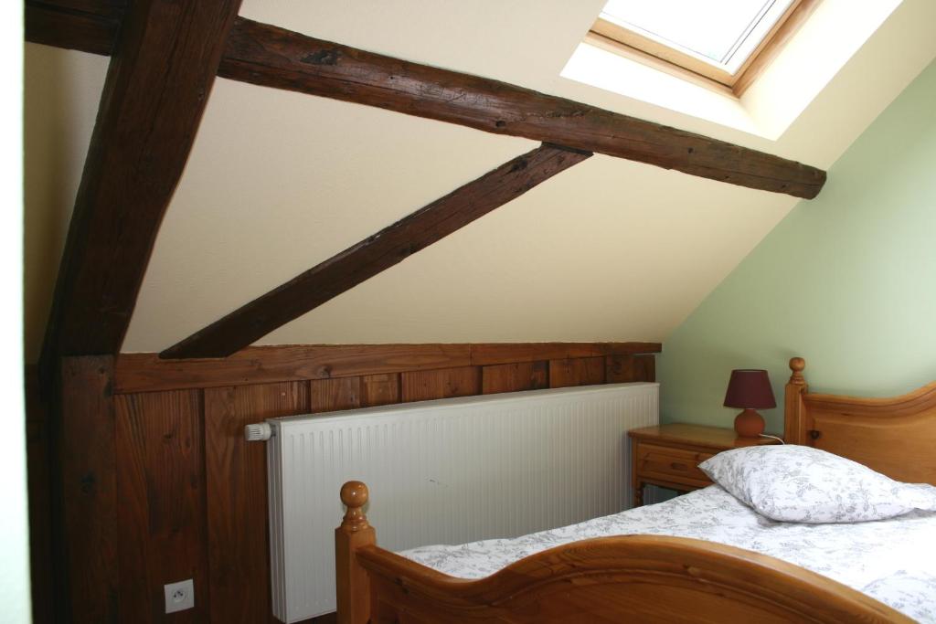 a bedroom with a bed and a skylight at G&icirc;tes du Kreuzweg in Le Hohwald