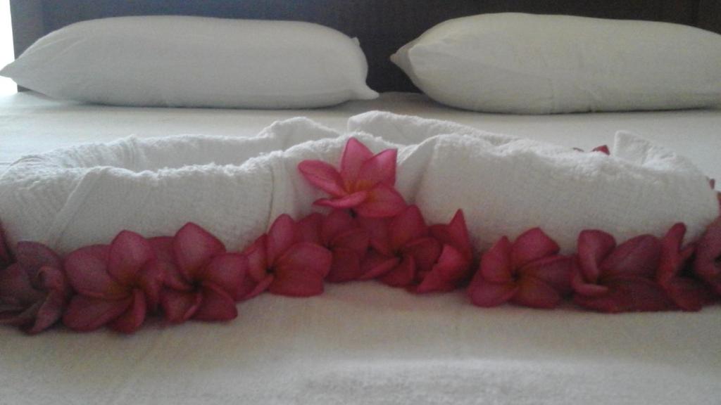 a white bed with pink flowers on it at Aurora Echo Villa in Matara