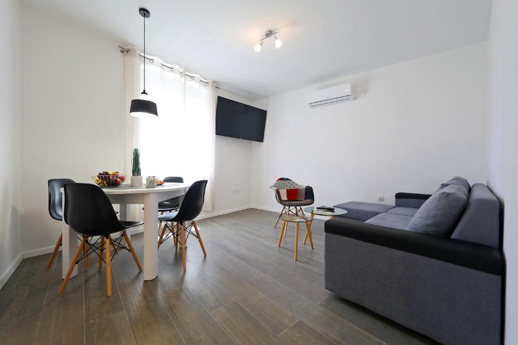 uma sala de estar com um sofá e uma mesa em Pyrotima Apartments em Zadar