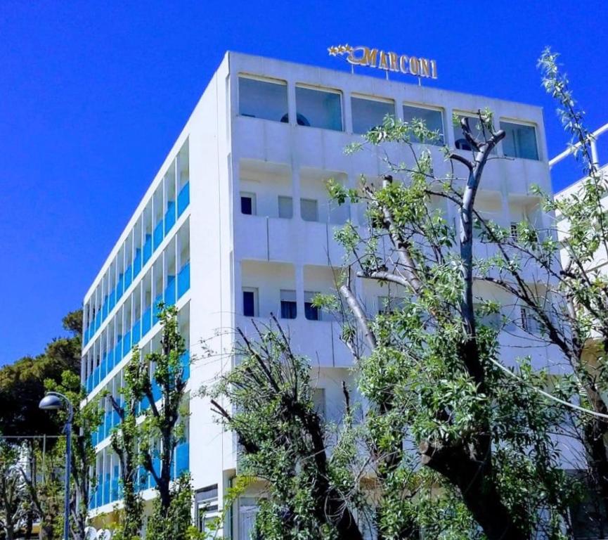 a white building with a sign on the side of it at Hotel Spiaggia Marconi in Rimini