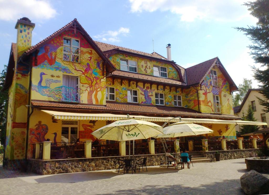 un grande edificio con ombrelloni di fronte di Hotel Encian a Rajecké Teplice