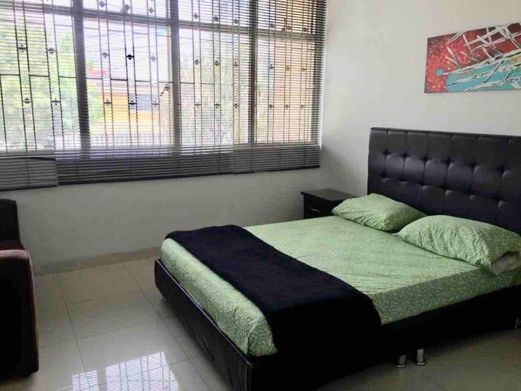 a bedroom with a bed with a large window at SPACIOUS STUDIO CENTRAL LOCATION (201) in Bogotá