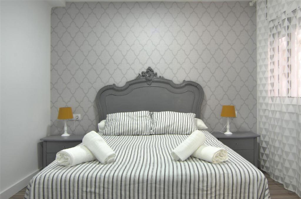 a white bedroom with a bed with white pillows at Apartment Ronda Sant Antoni in Girona