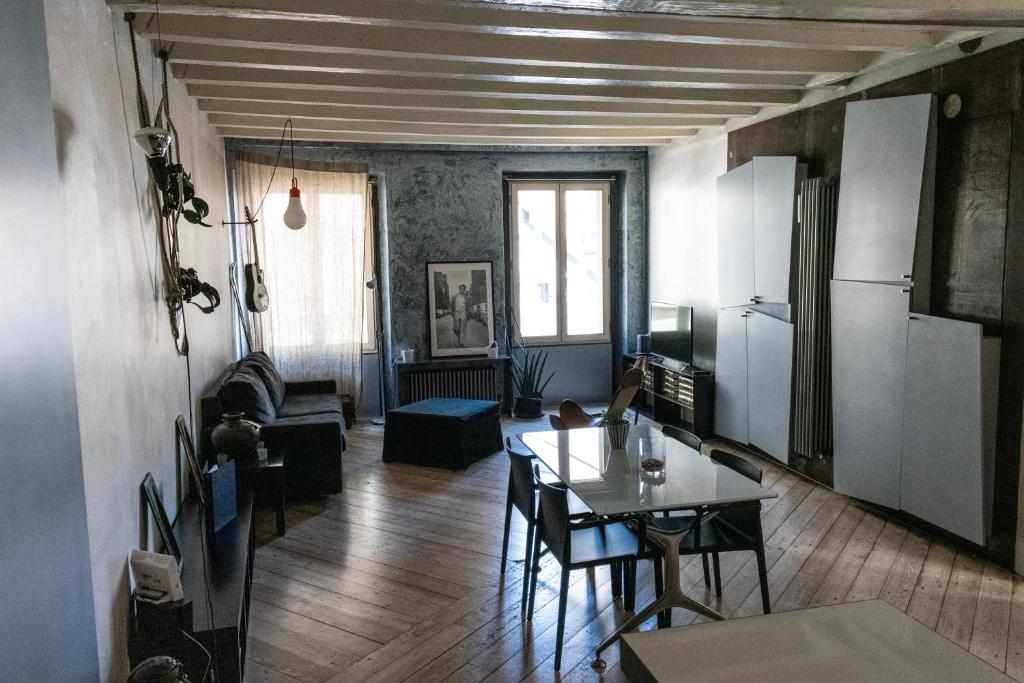 ein Wohnzimmer mit einem Tisch und einer Küche in der Unterkunft Flora Inn Flora I - Appartamento nel cuore di Piazza Vecchia in Bergamo